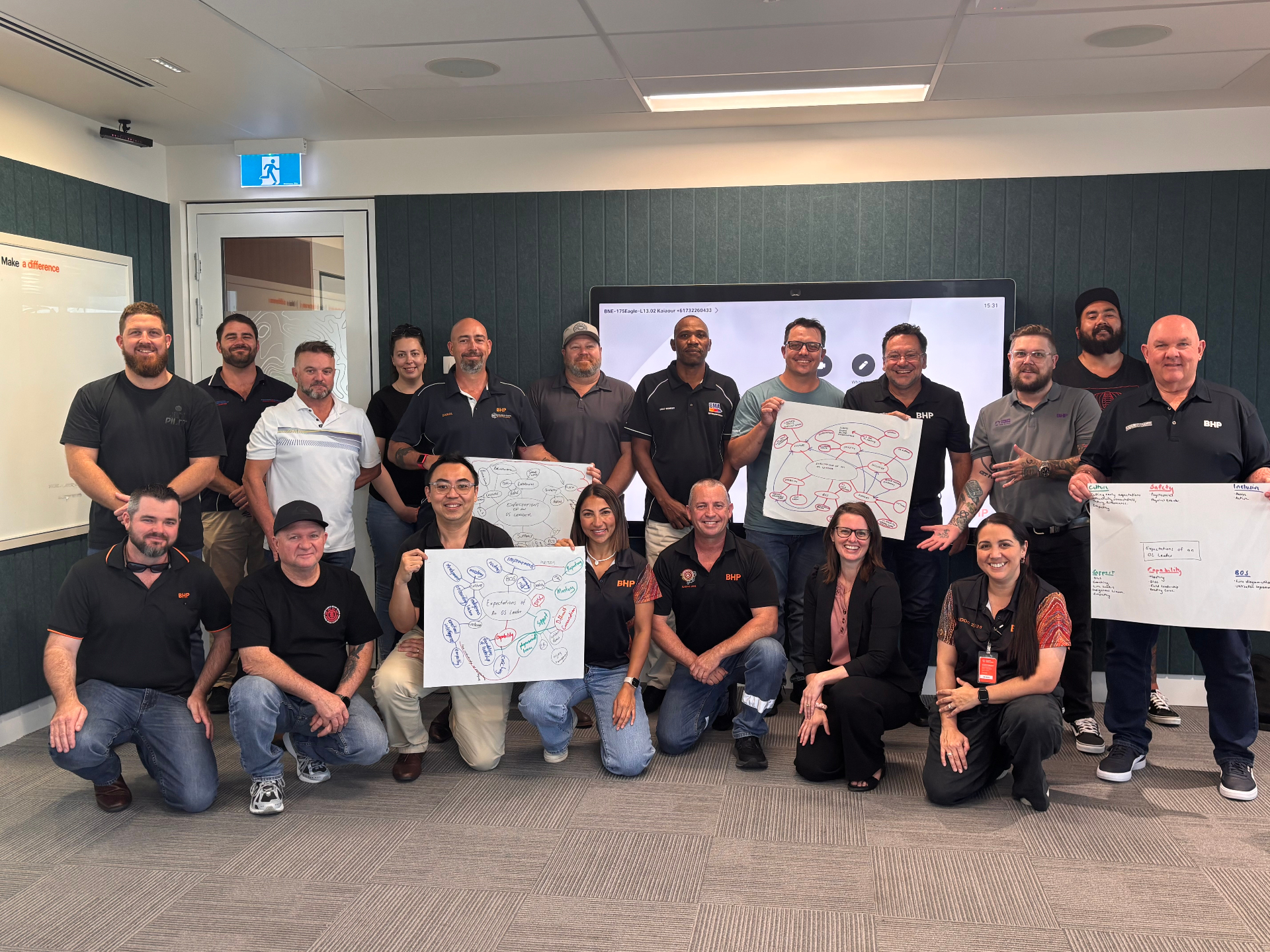 Cat with a BHP leadership cohort holding their workshop outputs
